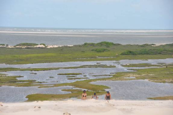 Chegando ao alto da duna, vista dos campos, lagoa e mar ao fundo, em Atins, nos Lençóis Maranhenses - MA